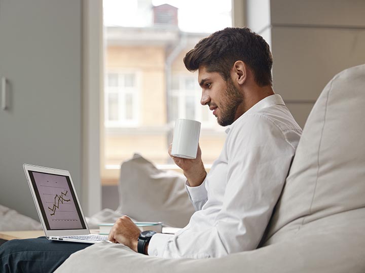 Businessman drink coffee and watch graph on laptop